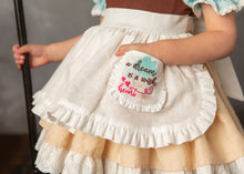 Load image into Gallery viewer, Close-up of girls work storybook dress with ruffled white apron and embroidered pocket