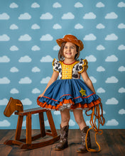 Load image into Gallery viewer, Girl wearing a cowgirl costume dress with cow print bodice, full chambray ruffle skirt and western details