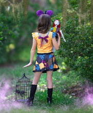 Load image into Gallery viewer, Back view of a girls Halloween play dress with a tie bow and colorful patchwork design.
