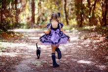 Load image into Gallery viewer, A black and purple boutique Halloween dress with a large bow, and black bat fabric on the skirt.