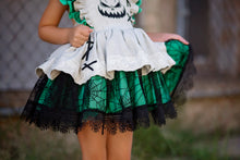 Load image into Gallery viewer, Layered skirt on a girls nightmare Halloween boutique dress with tan fabric, spiderweb overlay, green ruffles, and lace trim.