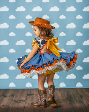 Load image into Gallery viewer, Girl wearing a western cowgirl costume dress with full blue chambray skirt, layered ruffles and large back bow