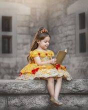 Load image into Gallery viewer, Girl reading a book while wearing a yellow storybook princess dress with gold lace and red bows